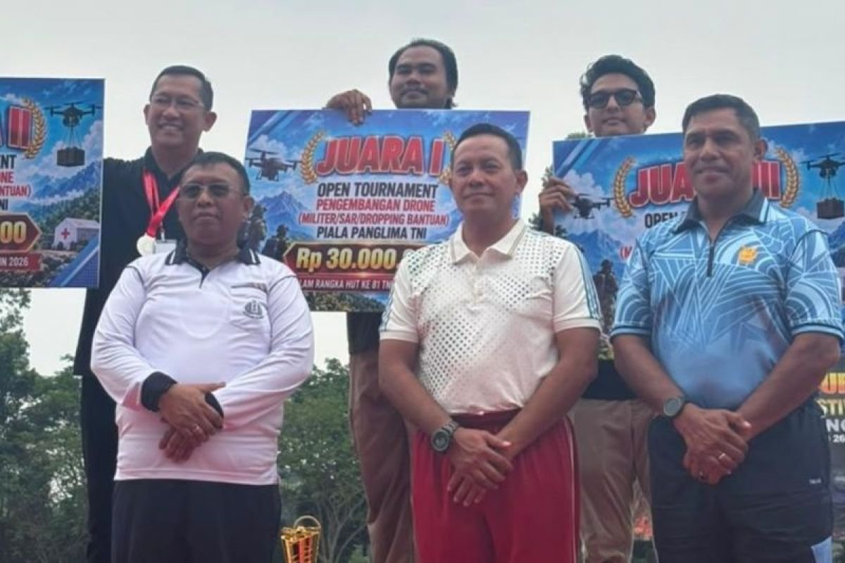 Officials stand behind a large presentation board for first place in the TNI Commander’s Cup open tournament for drone development