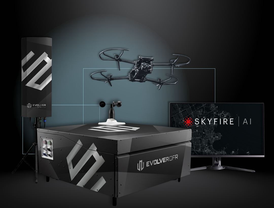 Evolver DFR system: a Parrot ANAFI UKR quadcopter hovering above a black DBOX docking station with a weather sensor on top, beside an antenna mast and a monitor showing SkyfireAI software