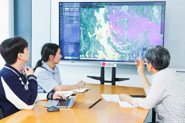 Staff review a map on a large display showing the iSAR search-and-rescue platform